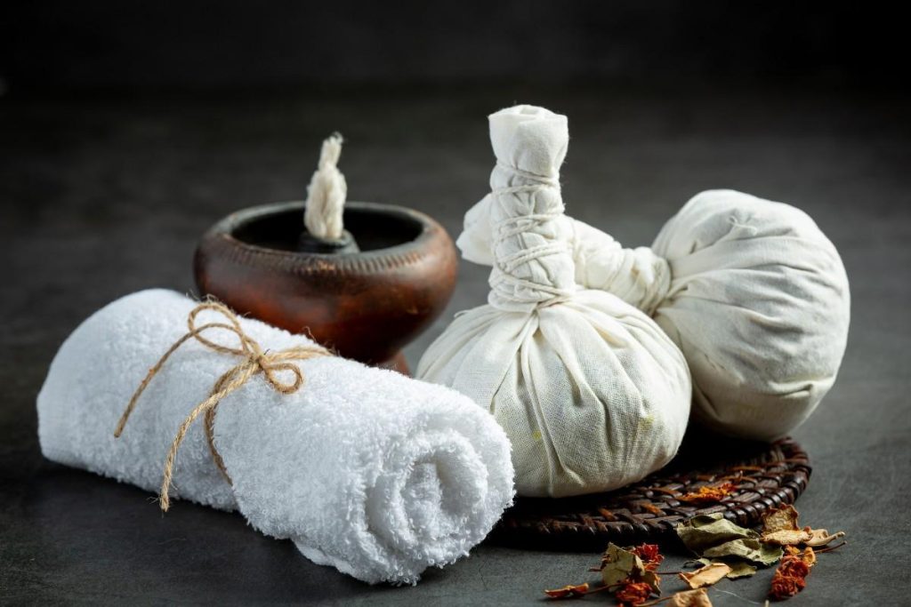 Traditional Ayurvedic therapy materials at an Authentic Kerala Panchakarma Centre featuring herbal poultices, treatment towels, and wellness therapy accessories.